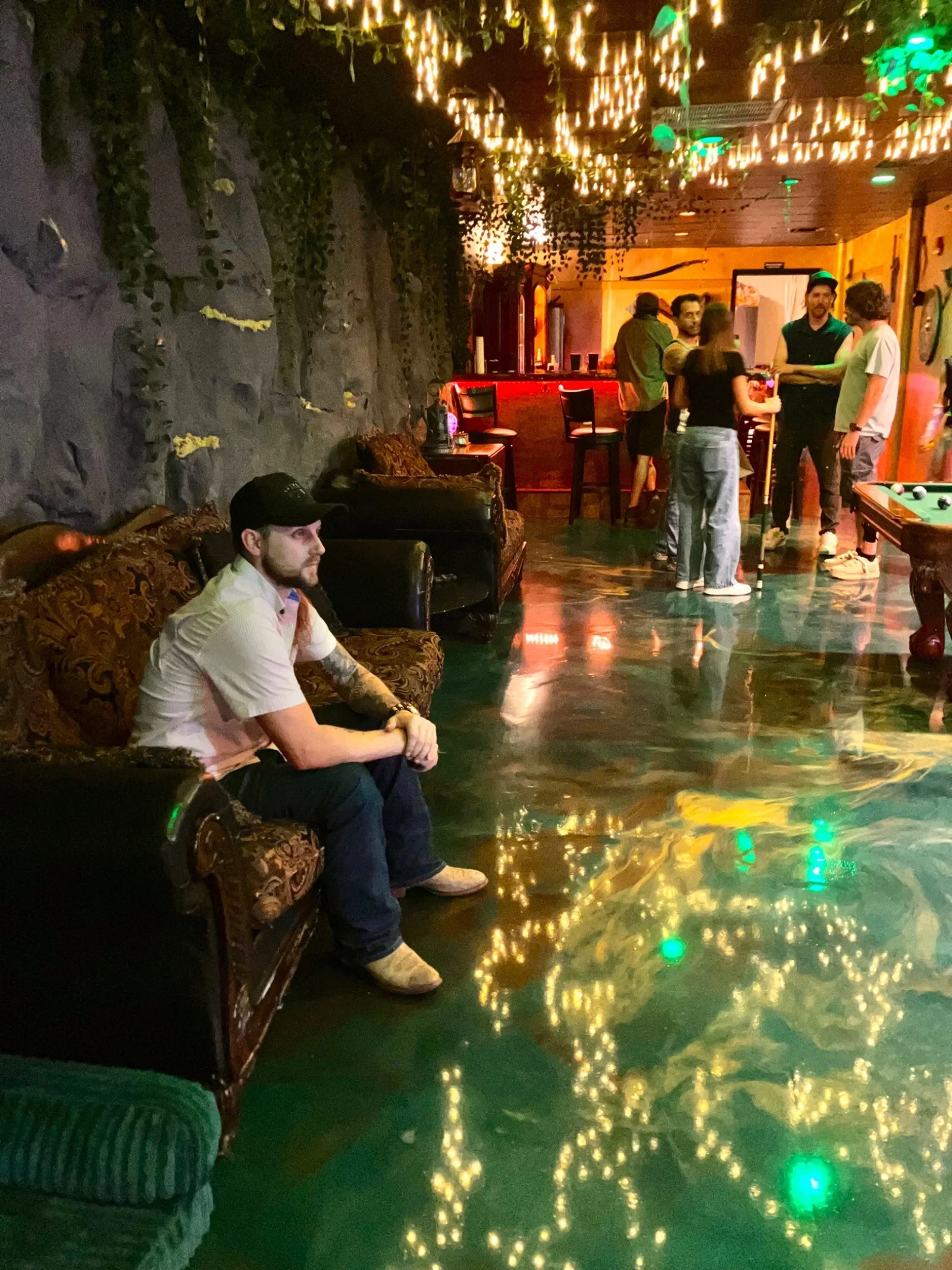 Guests in Moon and Root’s lounge beneath hanging plants and warm string lights