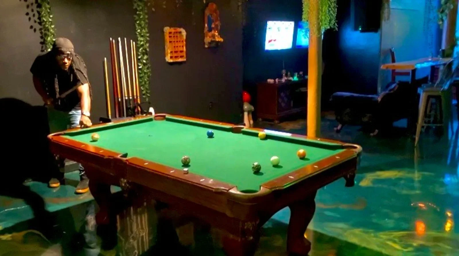 A pool table with guests playing in Moon and Root’s lounge