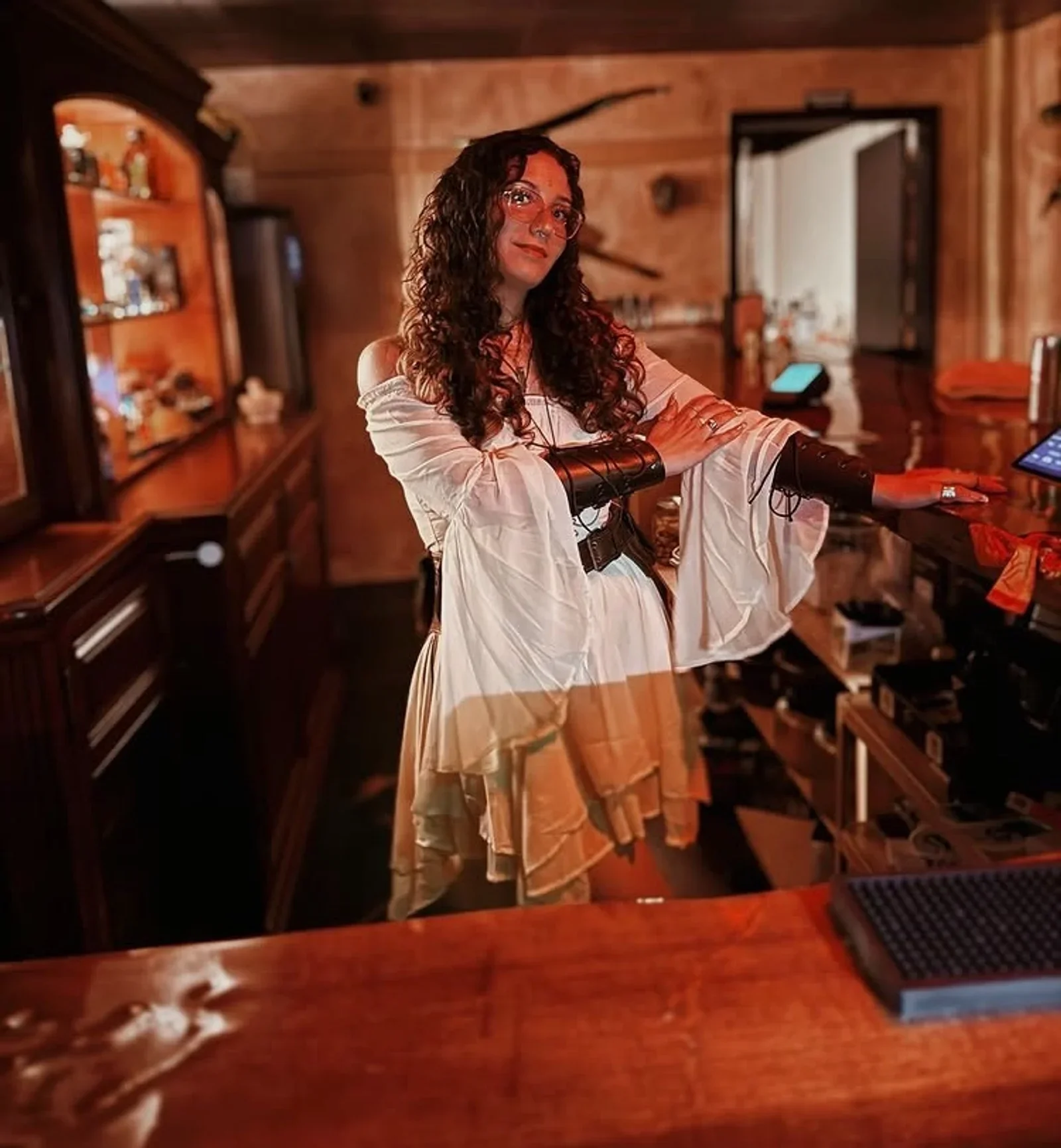 A costumed staff member welcoming guests at Moon and Root’s wooden bar