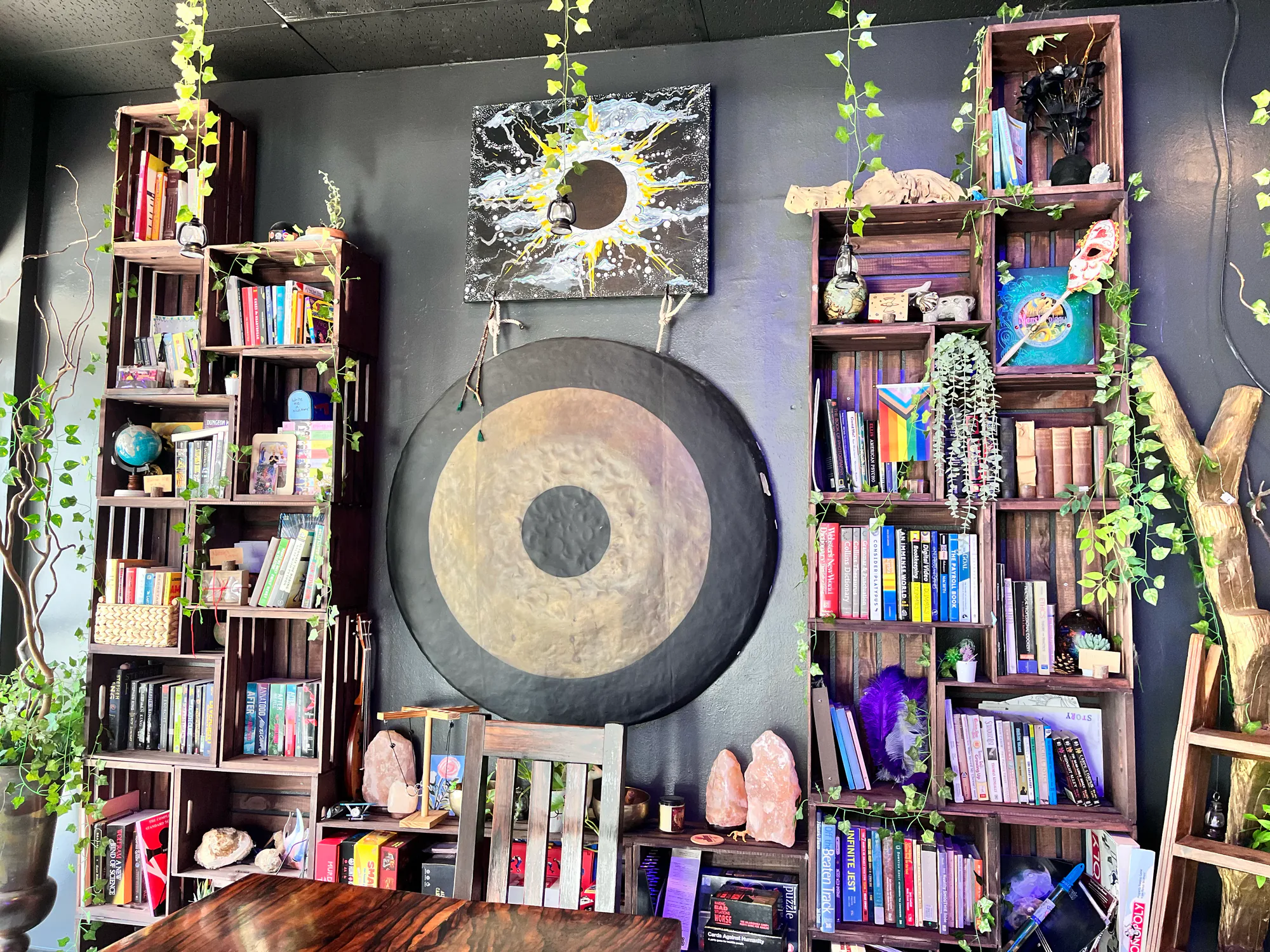 Bookshelves, a large gong, and communal seating fill a colorful corner of Tribe Tea Lounge